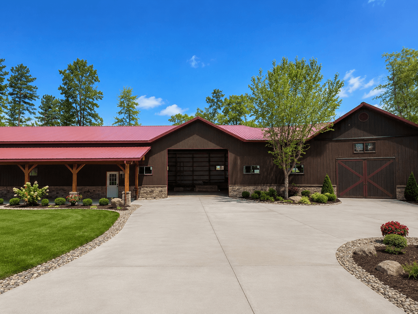 Finished commercial building with dark brown siding, red metal roof, stone wainscoting, and landscaped driveway